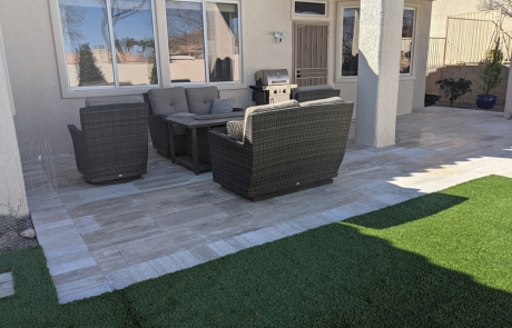 artificial-turf-lawn-with-stone-border.jpg Artificial turf lawn bordered with stone edging and desert plants.