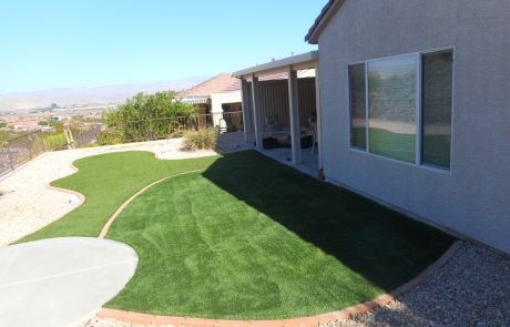 backyard-artificial-turf-lawn-with-rock-borders.jpg Backyard artificial turf lawn bordered with desert rocks and gravel.