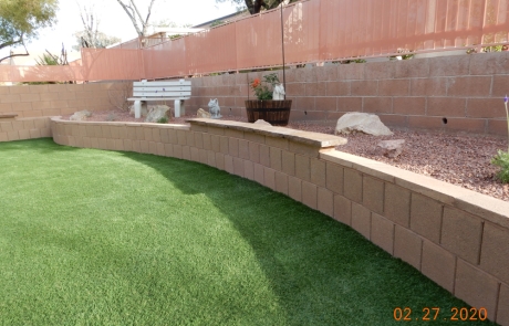 backyard-curved-block-retaining-wall-artificial-turf.jpg Backyard with curved block retaining wall and artificial turf lawn.
