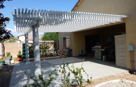backyard-pergola-with-concrete-patio.jpg Backyard concrete patio with white pergola providing shaded outdoor space.