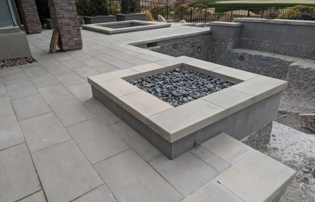 custom-stone-firepit-with-modern-patio.jpg Custom stone firepit with modern patio design and unfinished pool area.