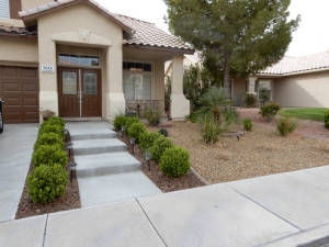 front-yard-steps-with-bushes-and-gravel-landscape.jpg Front yard concrete steps with trimmed bushes, pathway lighting, and gravel landscape.