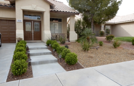 front-yard-steps-with-bushes-and-gravel-landscape.jpg Front yard concrete steps with trimmed bushes, pathway lighting, and gravel landscape.