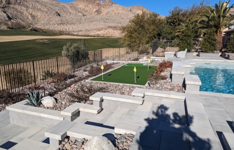 luxury-poolside-stonework-with-putting-green.jpg Luxury backyard with poolside stonework and small putting green.