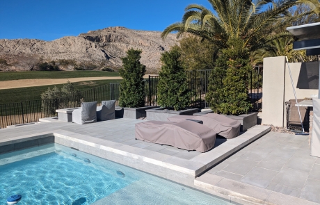 modern-stone-pool-deck-with-lounge-chairs.jpg Modern stone pool deck with lounge chairs and surrounding desert mountain view.
