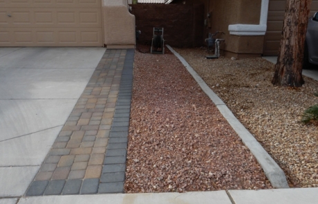 paver-driveway-border-with-rock-landscape.jpg Concrete driveway with custom paver border and rock landscape.