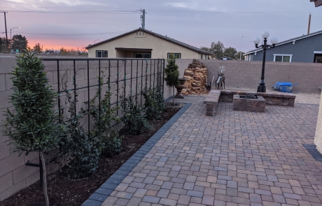 paver-patio-with-trellis-and-firepit.jpg Custom paver patio with trellis, built-in firepit, and decorative landscaping.